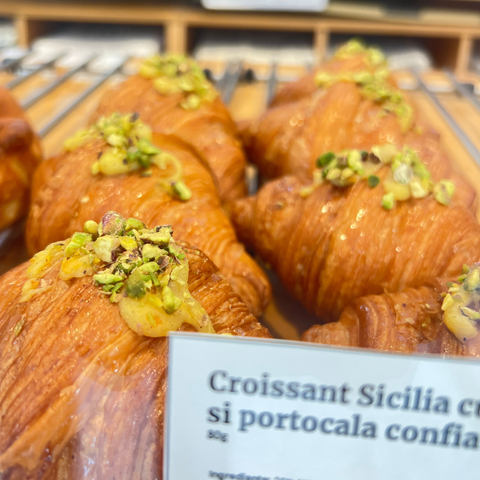 Croissantul Sicilia, cu miez cremos de vanilie și portocala confiată în vitrina Pain Plaisir